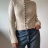 Isa Raglan Cardi av Aegyoknit, strikket i Merilin og Trio 1 fra Isager. En tettsittende cardigan med markante designelement som samler seg i en V foran og bak.